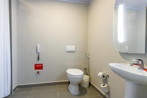 uma casa de banho com um WC branco e um lavatório. em Ibis Americana em Americana