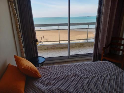 ブローニュ・シュル・メールにあるLa Pause Du Week Endのビーチの景色を望むベッドルーム1室(ベッド1台付)が備わります。