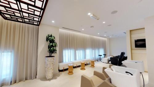 a living room with white furniture and a potted plant at The Hotel Galleria Jeddah, Curio Collection by Hilton in Jeddah
