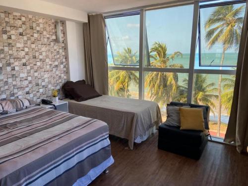 a hotel room with a bed and a large window at Flat vista Mar in João Pessoa