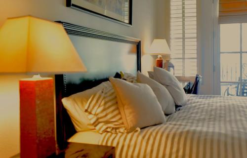 a bedroom with a bed with white pillows and a lamp at Beautiful Casita, La Quinta Legacy Villas Resort in La Quinta