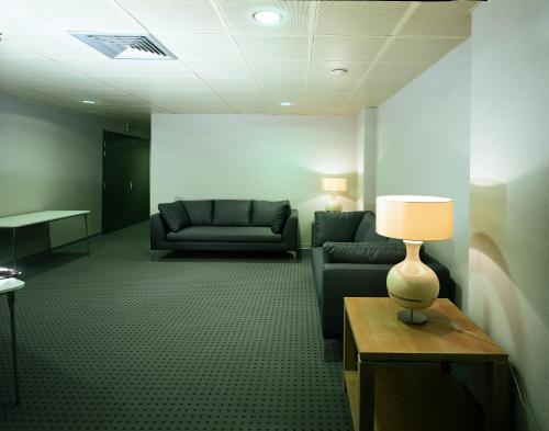 a waiting room with couches and a lamp on a table at Meridiana Country Hotel in Calenzano