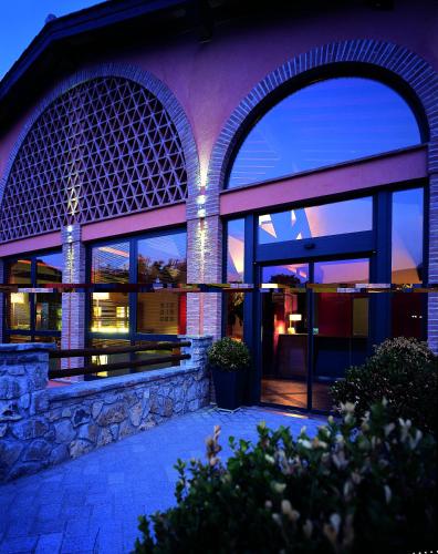 a building with two large windows with lights in it at Meridiana Country Hotel in Calenzano