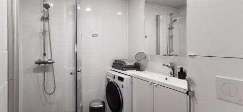 a bathroom with a shower and a washing machine at New and cozy apartment in the centrum of Oulu in Oulu
