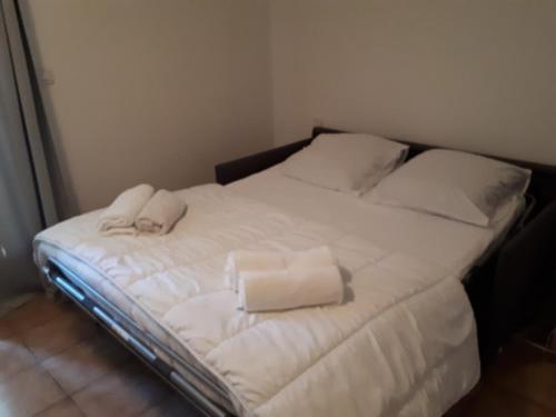 Una cama blanca con dos toallas encima. en Lalbatros, en Mouans-Sartoux