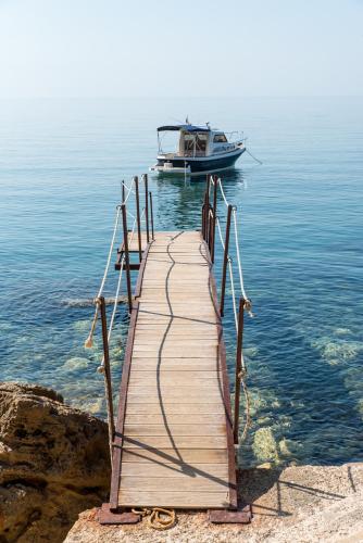 a wooden dock with a boat in the water at Apartments Eneida in Ulcinj