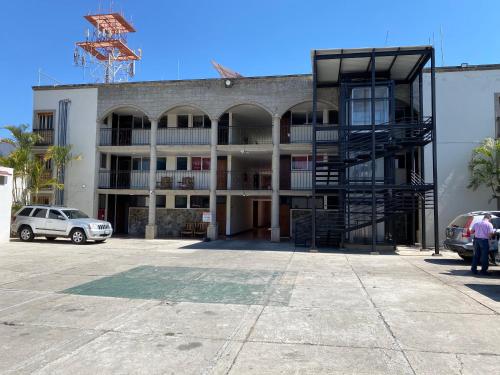 un edificio con un estacionamiento delante de él en HOTEL FLAMINGOS DE CIUDAD GUZMAN, en Ciudad Guzmán