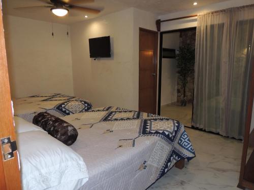 a bedroom with a bed and a flat screen tv at Hotel Boutique Bugambilias in Valladolid
