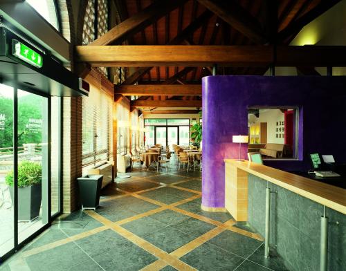 a restaurant with a bar with purple walls and tables at Meridiana Country Hotel in Calenzano