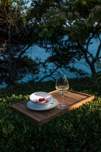 a wooden table with a plate and a glass of wine at Apartments Eneida in Ulcinj