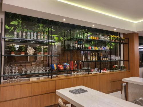 a restaurant with a bar with glasses and plants at Class Hotel Piracicaba in Piracicaba