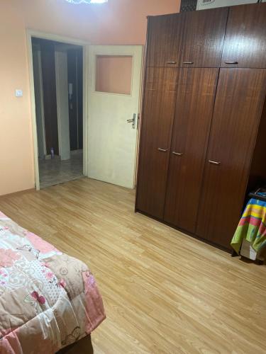 a bedroom with a large closet and a wooden floor at Апартамент in Varna City