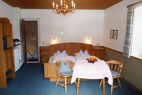 a bedroom with a bed and a table and chairs at Maiergschwendter-Hof in Ruhpolding