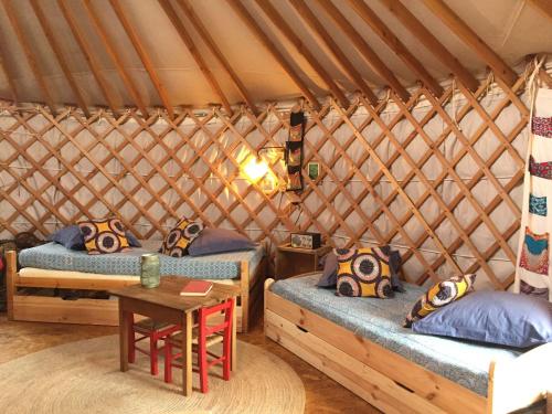 een kamer met 2 bedden en een tafel in een yurt bij La Yourte in Moussages