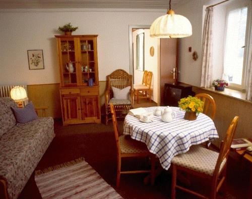sala de estar con mesa y sofá en Maiergschwendter-Hof en Ruhpolding