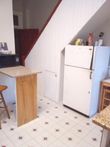 a kitchen with a white refrigerator and a staircase at Orange Wildflowers in Richmond