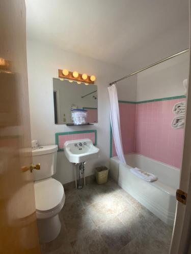 a bathroom with a toilet and a sink and a tub at Lamplighter Lodge in Panguitch