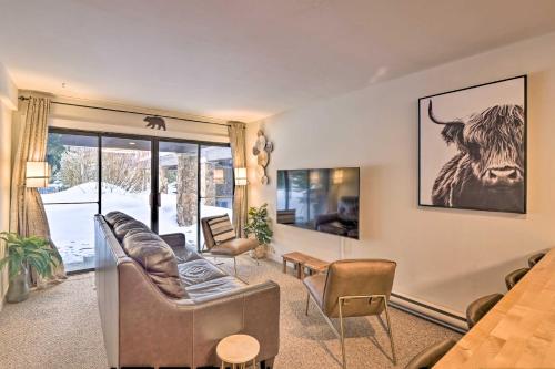 a living room with a couch and a cow on the wall at Ski-InandSki-Out Condo with Hot Tub on Copper Mountain in Frisco