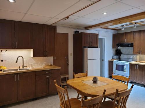 a kitchen with wooden cabinets and a wooden table at Whispering Pines Suite at The Bowering Lodge in Blue Mountains