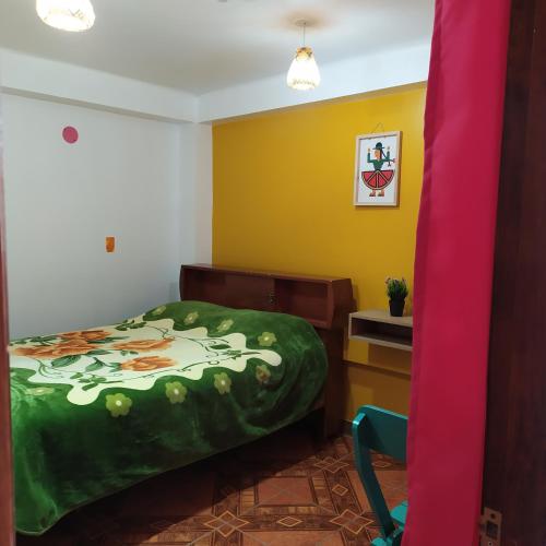 a bedroom with a bed and a desk and a pink curtain at The Chusay Rooftop in Cusco