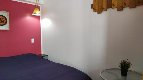 a bedroom with a blue bed and a glass table at The Chusay Rooftop in Cusco