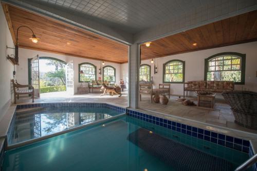 a swimming pool in a house with a dog in it at Confraria Colonial Hotel Boutique in Mairinque