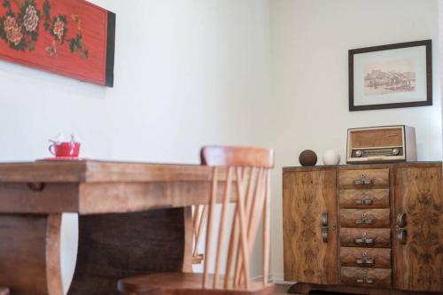 a wooden desk with a wooden chair next to a dresser at BABhouse Casa da Mata - Coração do Douro in Nagoselo do Douro