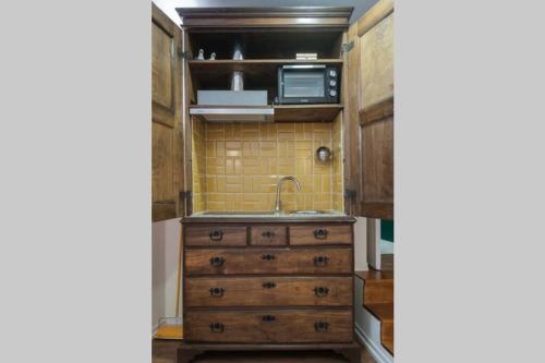 a kitchen with a sink and a wooden dresser at BABhouse Casa da Mata - Coração do Douro in Nagoselo do Douro
