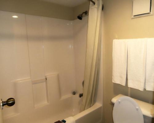 a white bathroom with a shower and a toilet at Americas Best Value Inn Tucker in Tucker