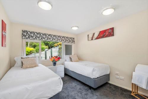 a bedroom with two beds and a window at Acacia Waters - Lake Taupo in Taupo