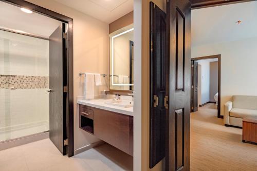 La salle de bains est pourvue d'un lavabo, d'une douche et d'un miroir. dans l'établissement Staybridge Suites - Saltillo, an IHG Hotel, à Saltillo