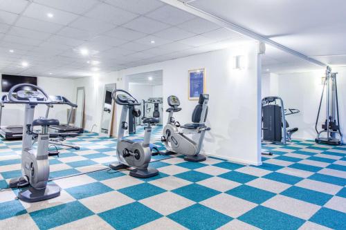 a gym with treadmills and ellipticals on a checkered floor at Radisson Blu Hotel Malmö in Malmö