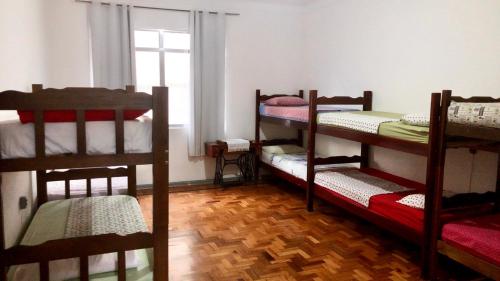 Hostel Tropeiro de Minas في جويز دي فورا: غرفة بها ثلاثة أسرة بطابقين ونافذة
