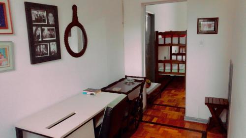 a room with a table and a bed in it at Hostel Tropeiro de Minas in Juiz de Fora