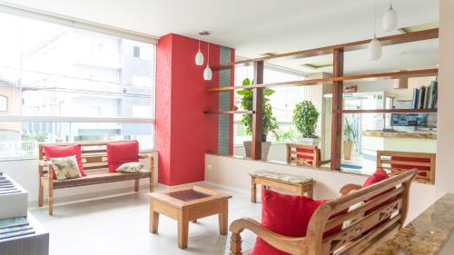 sala de estar con pared de acento rojo en UPG Hotel, en Ubatuba