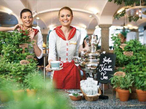 zwei Frauen in einem Blumenladen mit einer Tasse Kaffee in der Unterkunft Landzeit Autobahn-Restaurant Steinhäusl bei Wien in Altlengbach
