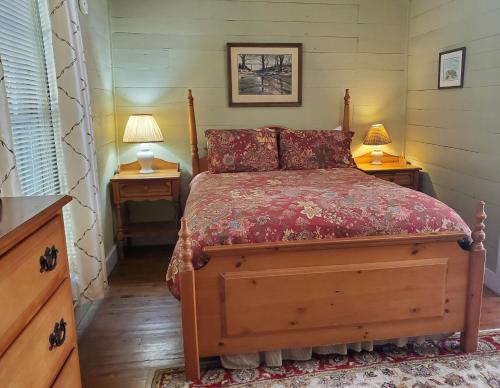 een slaapkamer met een bed met 2 nachtkastjes en 2 lampen bij The Cabins at Healing Springs in Crumpler