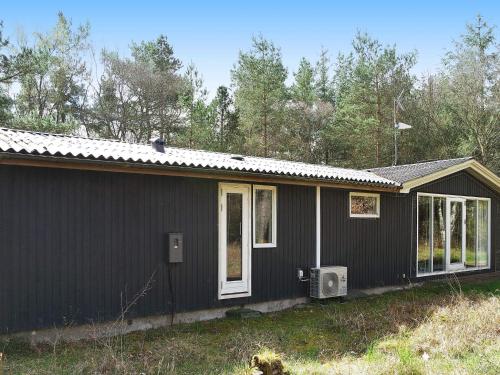 Helberskovにある8 person holiday home in Hadsundの白窓のある黒い家