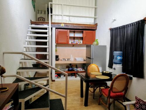 Habitación con escalera, mesa y nevera. en Margaritas101, en Cancún