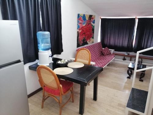 uma sala de estar com uma mesa e cadeiras e um frigorífico em Margaritas101 em Cancún