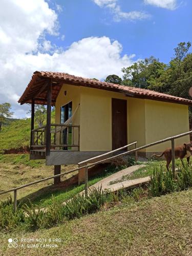 ein kleines Haus mit einem Pferd davor in der Unterkunft Pousada Espaço da Onça in Lumiar