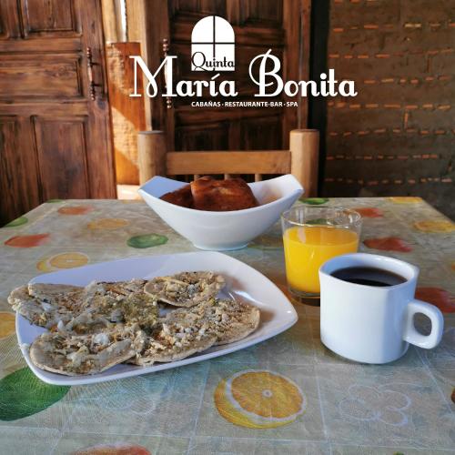 a table with a plate of food and a cup of coffee at Quinta Maria Bonita in Zacatlán