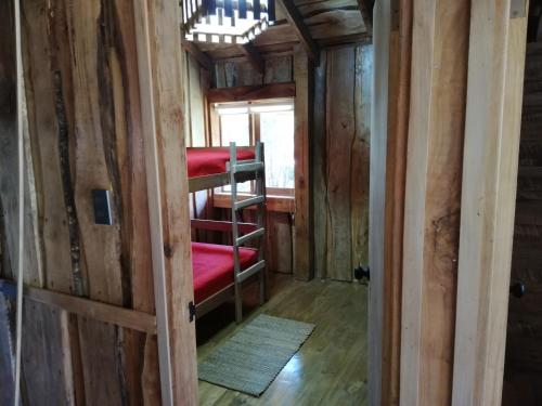 a room with bunk beds in a wooden house at Cabañas Rústicas Pucón Río Trancura in Pucón