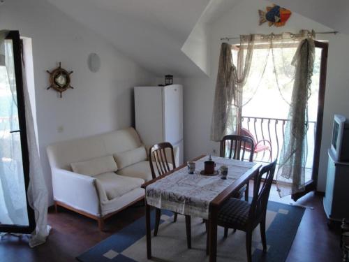 ein Wohnzimmer mit einem Tisch, Stühlen und einem Sofa in der Unterkunft Apartments Niki - 5m from the sea in Drvenik Veli
