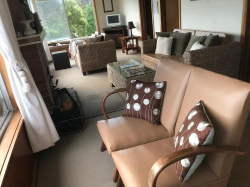 a living room with a couch with pillows on it at Summertime Cottage in Southport