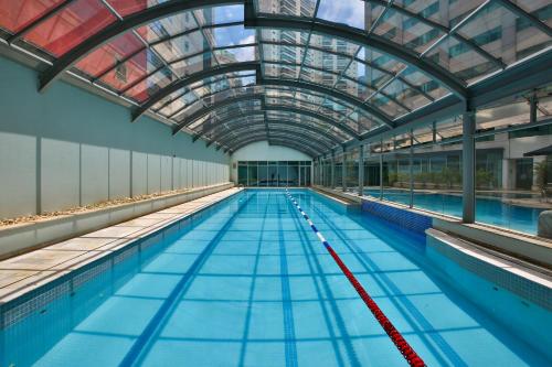 an indoor swimming pool with a glass ceiling at Radisson Vila Olimpia Sao Paulo in Sao Paulo