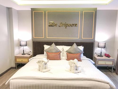 a bedroom with a large white bed with two tables at Hotel De Sripoom in Chiang Mai