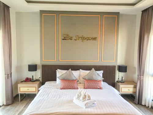 a bedroom with a bed with two shoes on it at Hotel De Sripoom in Chiang Mai