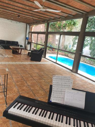 un piano en una sala de estar con piscina en Gachishouse en Buenos Aires