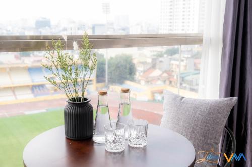 two bottles and glasses on a table with a window at Libré Homestay in Hanoi